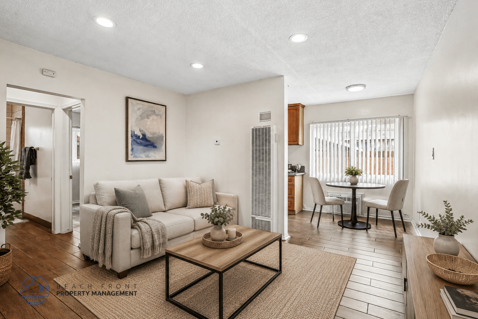 A living room with a couch, a coffee table, and a dining table with chairs.